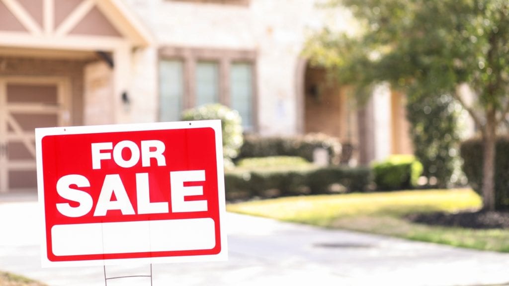 for sale sign in front of a house