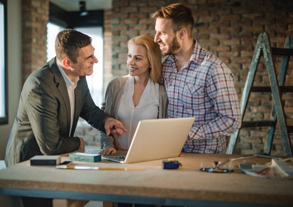 husband and wife talking to a real estate agent about buying a new construction home